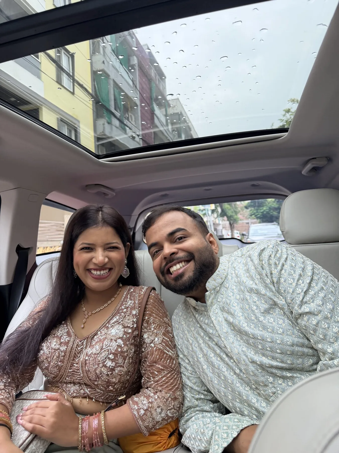 The two of us dressed up in the back of a car on a rainy day