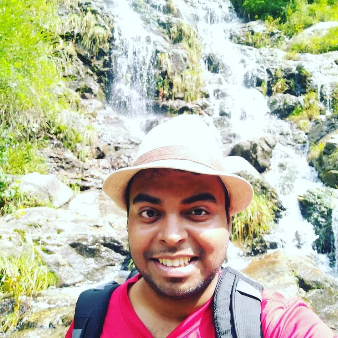 Lucky Sahani on a trek, in front of a waterfall